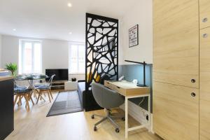 un bureau avec un bureau, une table et des chaises dans l'établissement expat renting - Entre Piment & Violette - Saint Michel, à Toulouse