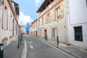 une rue vide dans une ruelle avec des bâtiments dans l'établissement expat renting - Entre Piment & Violette - Saint Michel, à Toulouse
