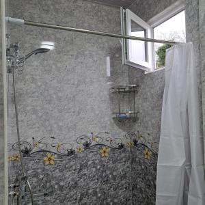 a bathroom with a shower with a shower curtain at Nika house in Tsqaltubo +47 photos