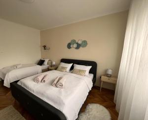 a bedroom with two beds with towels on them at Apartman Cvjetnjak in Čakovec