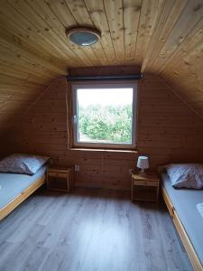 two beds in a room with a window at U Benka in Wisełka