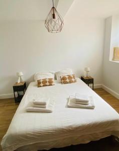 a bedroom with a large white bed with towels on it at Family house Bordeaux centre, pool, garden, air conditioning in Bordeaux +24 photos