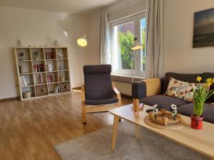 ザンクト・ペーター・オルディングにあるFerienhaus Op de Diekのソファとテーブルと椅子のあるリビングルーム