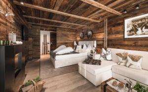 a living room with white furniture and wooden walls at Alpin Boutique Villa Gabriela - Adults Only in Castelrotto