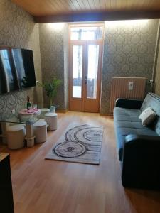 ein Wohnzimmer mit einem blauen Sofa und einer Tür in der Unterkunft Ferienwohnung Gabry in Saarlouis