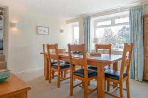 a dining room with a wooden table and chairs at Compass Cottage in Abersoch