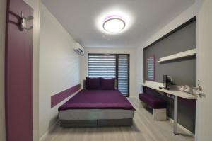ヴェリコ・タルノヴォにあるApartment Relaxの紫色のベッドとデスクが備わるベッドルーム1室が備わります。