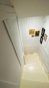 um quarto com uma escada branca com fotografias na parede em Chez Brigitte em Bar-sur-Seine