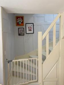 uma escada branca num quarto com fotografias na parede em Chez Brigitte em Bar-sur-Seine