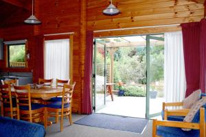 a kitchen and dining room with a table and chairs at The Chalets Motel in Hanmer Springs