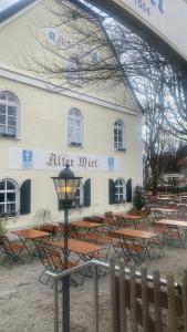 Ein Gebäude mit einem Haufen Tische davor. in der Unterkunft Alter Wirt Ramersdorf in München