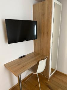 a desk with a flat screen tv on a wall at Alter Wirt Ramersdorf in Munich