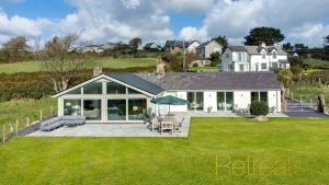 a large white house with a patio and lawn at Hyfrydle in Mynytho