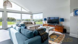 a living room with a couch and a tv at Hyfrydle in Mynytho