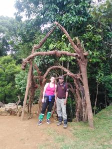 two people standing in front of a tree arch at Deniyaya Guest House in Deniyaya