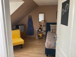 um quarto com uma cama e uma cadeira amarela em B&B Holiday-44 em Enkhuizen