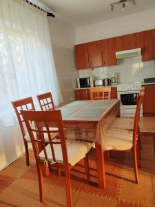 eine Küche mit einem Esstisch aus Holz und Stühlen in der Unterkunft Guesthouse Resan in Medulin