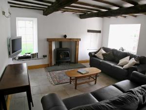 a living room with a couch and a fireplace at The Larches in Kirkby Stephen