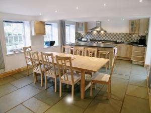 an open kitchen with a wooden table and chairs at The Larches in Kirkby Stephen