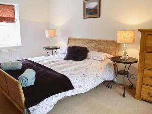 a bedroom with a bed and two tables with lamps at The Larches in Kirkby Stephen