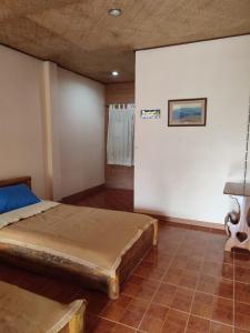 ein Schlafzimmer mit einem Bett und einer weißen Wand in der Unterkunft Topp Villa Garden in Pai