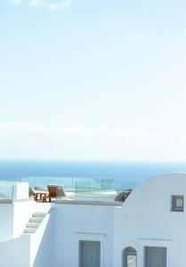 a view of the ocean from the balcony of a house at Astro Palace Hotel & Suites in Fira