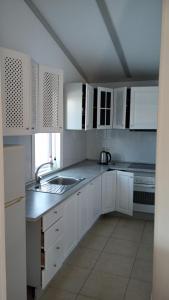 uma cozinha branca com armários brancos e um lavatório em Villas del Alba em Alhaurín de la Torre
