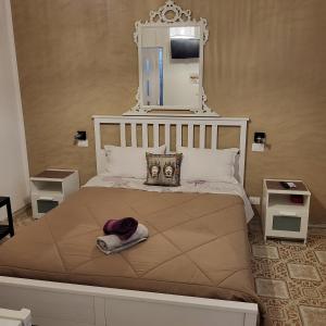una camera da letto con un grande letto con uno specchio sopra di "Da Nina" a Lascari