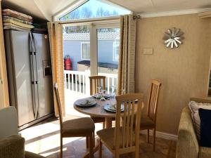 a dining room with a table and chairs and a balcony at Whitwell and Reepham Station - GEORGIE in Reepham