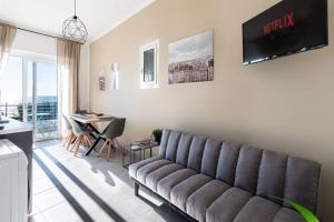 a living room with a couch and a table at Esclusivo alloggio a sfioro sul mare con terrazza. in Santa Maria di Castellabate