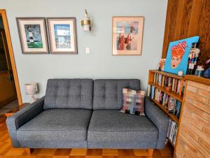 a couch in a living room with a book shelf at Jamaica Mid-Century in Seaton