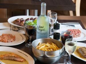 una mesa con platos de comida y una botella de vino en ibis Styles Evry Courcouronnes Hotel and Events, en Courcouronnes