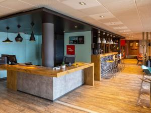 - un hall d'un restaurant avec un comptoir et des chaises dans l'établissement ibis Saint-Malo Madeleine, à Saint-Malo