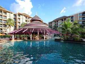 Novotel Phuket Vintage Park Resort في شاطيء باتونغ: مسبح مع شرفة امام الفندق