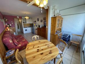 kuchnia i salon z drewnianym stołem i krzesłami w obiekcie Studio cabine avec piscine à Saint-Cyprien, plage à 50m - FR-1-106-76 w mieście Saint-Cyprien
