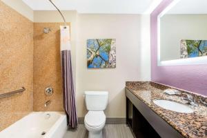 a bathroom with a toilet and a sink and a tub at La Quinta by Wyndham Hillsboro in Hillsboro +23 photos