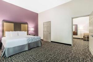 um quarto de hotel com uma cama e um espelho grande em La Quinta by Wyndham Hillsboro em Hillsboro