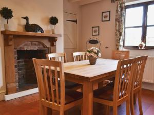 a dining room table with chairs and a fireplace at Bridge House in Church Gresley
