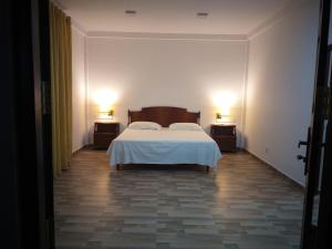 a bedroom with a bed and two lamps on two tables at Hotel La Felicita in Mirissa