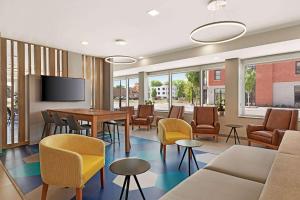 Microtel Inn & Suites by Wyndham Lachute في Lachute: غرفة انتظار مع طاولة وكراسي