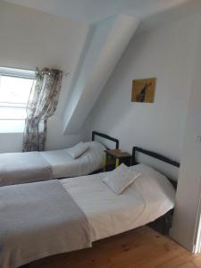 um quarto com 2 camas e uma janela em Les gîtes de Denise, proche Saint-Malo au calme em Bonnemain