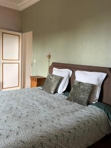 - une chambre avec un lit et des oreillers dans l'établissement Les chambres d'Omaha Beach Etablissement avec deux chambres d'hôtes, petit-déjeuner compris fait-maison et produits locaux, à Vierville-sur-Mer