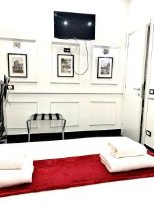 a living room with a red rug and a tv at L'antica Locanda Dell'Orso in Rome