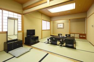 um quarto com um quarto com uma mesa e um espelho em Hotel New Omi em Omihachiman