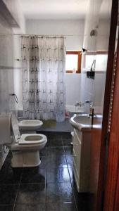 a bathroom with a toilet and a sink and a shower at Casa Cosme in Braga