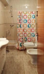 a bathroom with a toilet and a shower curtain at Casa Cosme in Braga