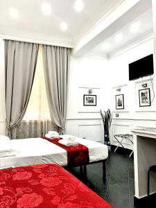 a hotel room with two beds and a desk at L'antica Locanda Dell'Orso in Rome