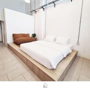 1 cama en una plataforma de madera en una habitación en The Companion, en Bangkok