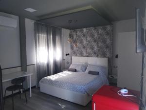 a bedroom with a white bed and a red suitcase at B&B Marino in Grisolia