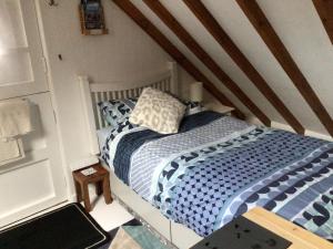 een kleine slaapkamer met een bed op zolder bij Cozy Camborne Studio Retreat with two single beds in Camborne
